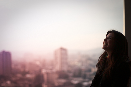 Happy Woman Looking out Office Window