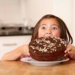Little Girl about to Chomp Down on Big Chocolate Cake