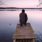 Man Reflecting on Dock at Lake