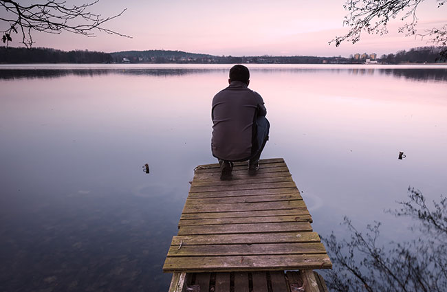 Man Reflecting on Dock at Lake