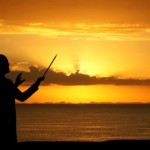Conductor Conducting the Sunset over Ocean